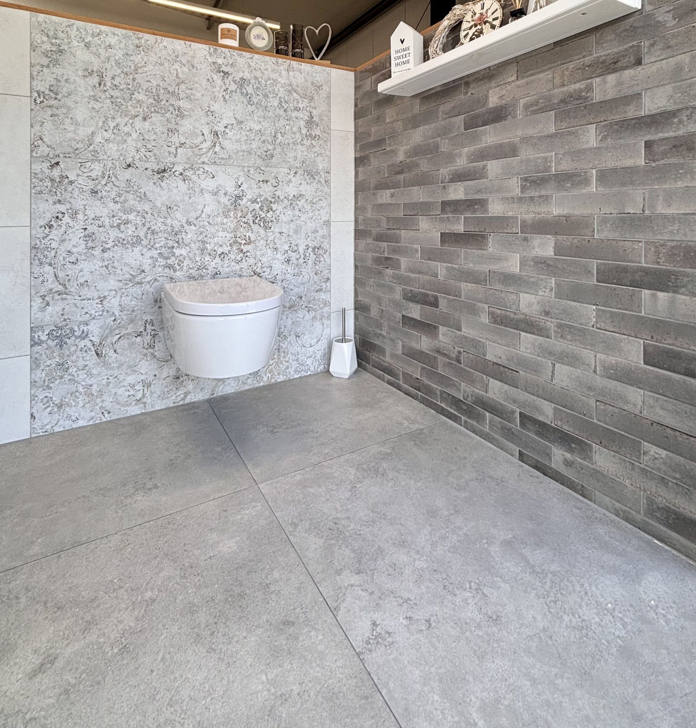 Nahaufnahme von großformatigen Fliesenmustern in einem Fliesenausstellungsständer, im Vordergrund eine glänzend weiße und eine rote Fliese.