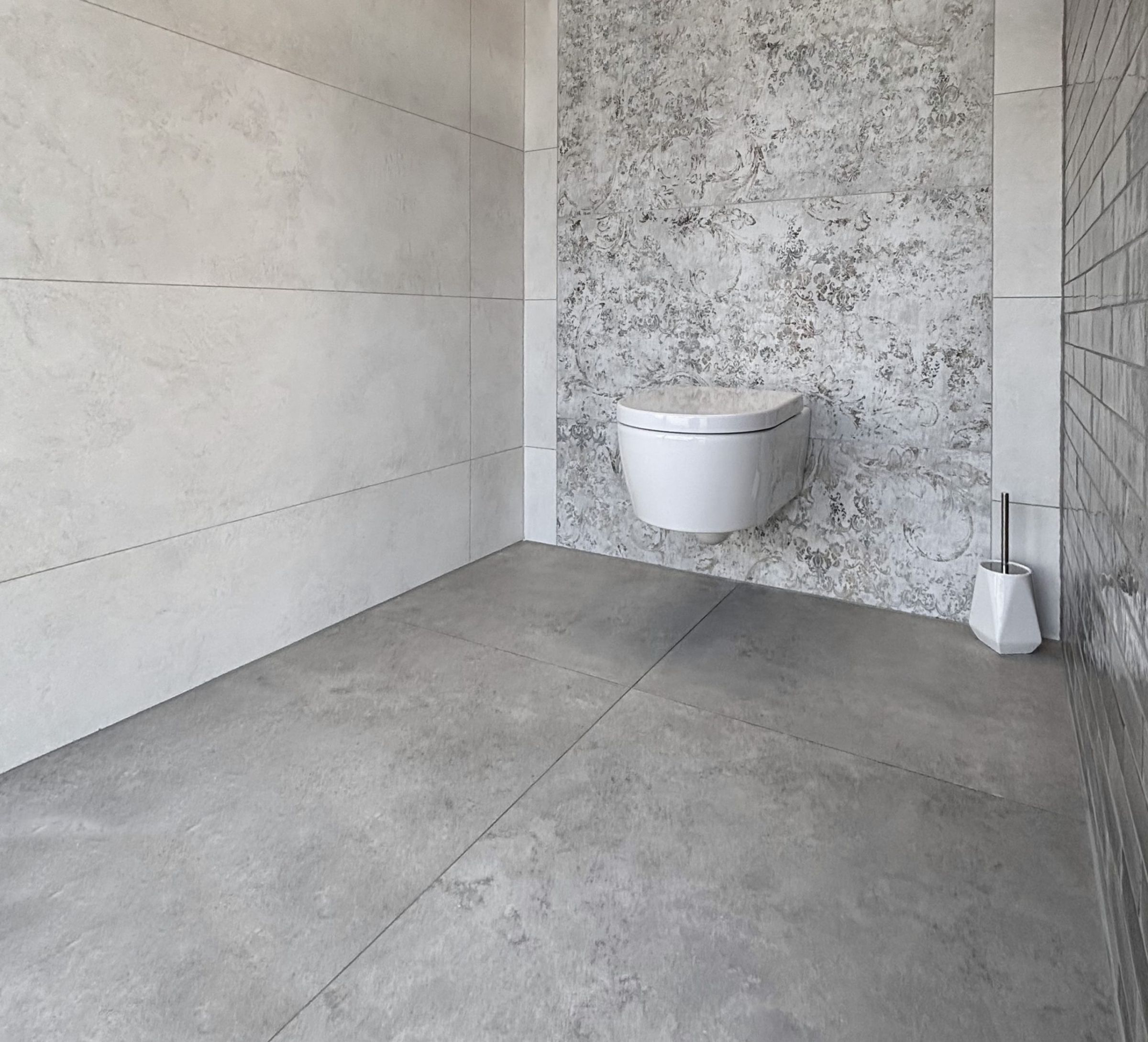 Nahaufnahme von großformatigen Fliesenmustern in einem Fliesenausstellungsständer, im Vordergrund eine glänzend weiße und eine rote Fliese.