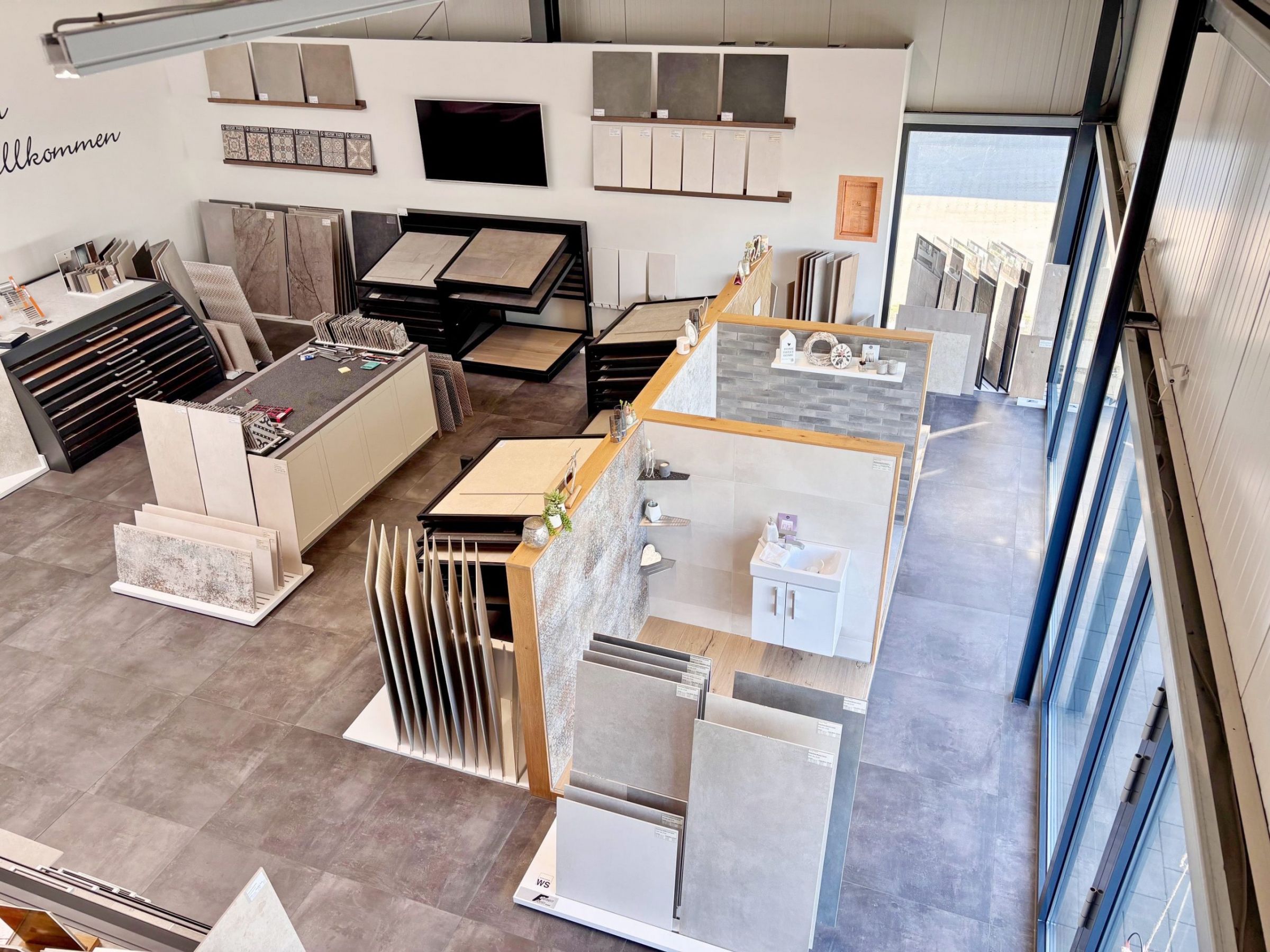 Nahaufnahme von großformatigen Fliesenmustern in einem Fliesenausstellungsständer, im Vordergrund eine glänzend weiße und eine rote Fliese.